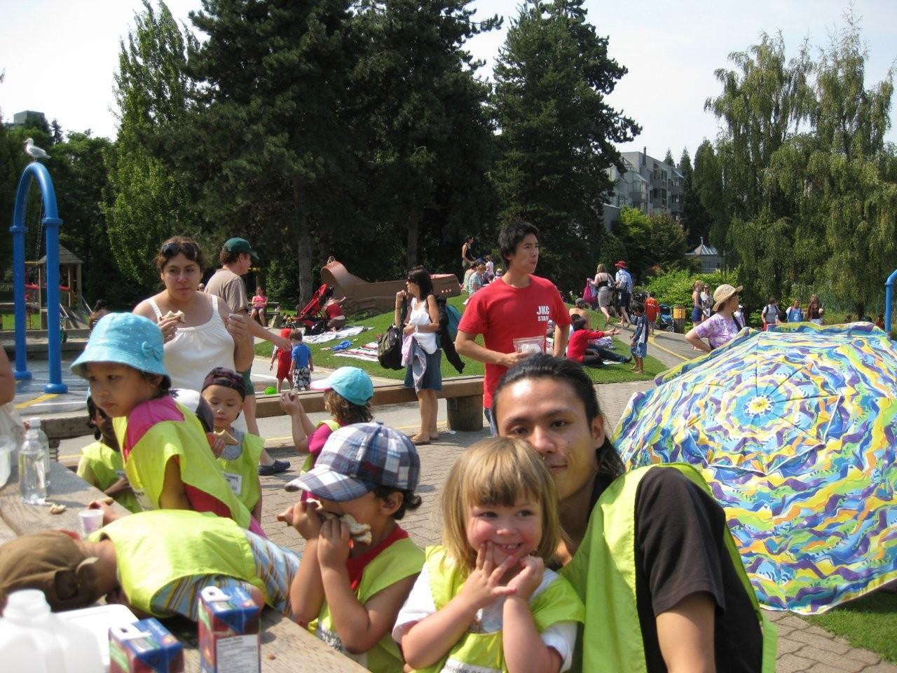 公園でお昼ごはんを食べる子どもたちとボランティア